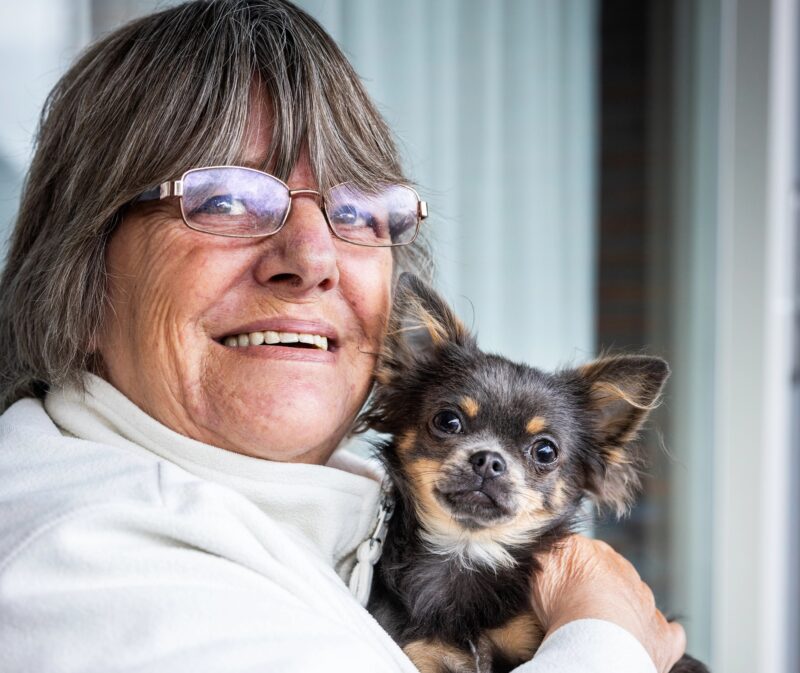 Cliënt knuffelt met hondje Sammy