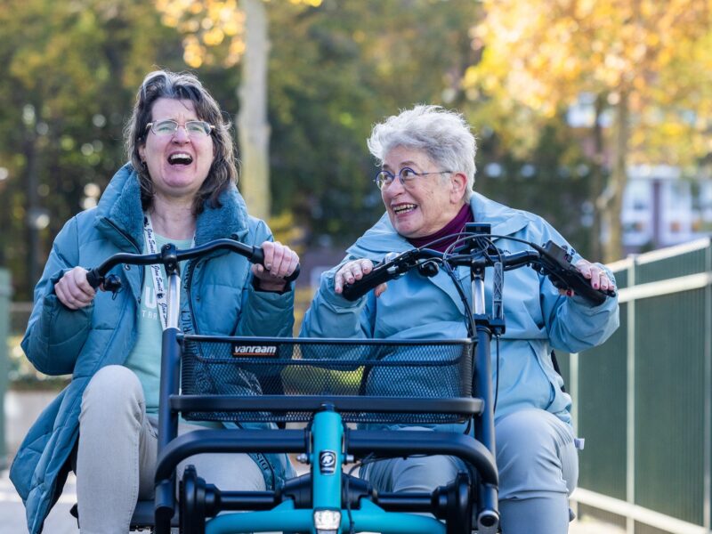 Voorzitter van de Vrienden van ORO op een duofiets met cliënt